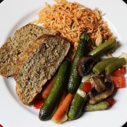 A plate of meatloaf, rice, and vegetables