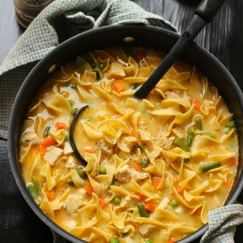 close up of pot of creamy chicken noodle soup.