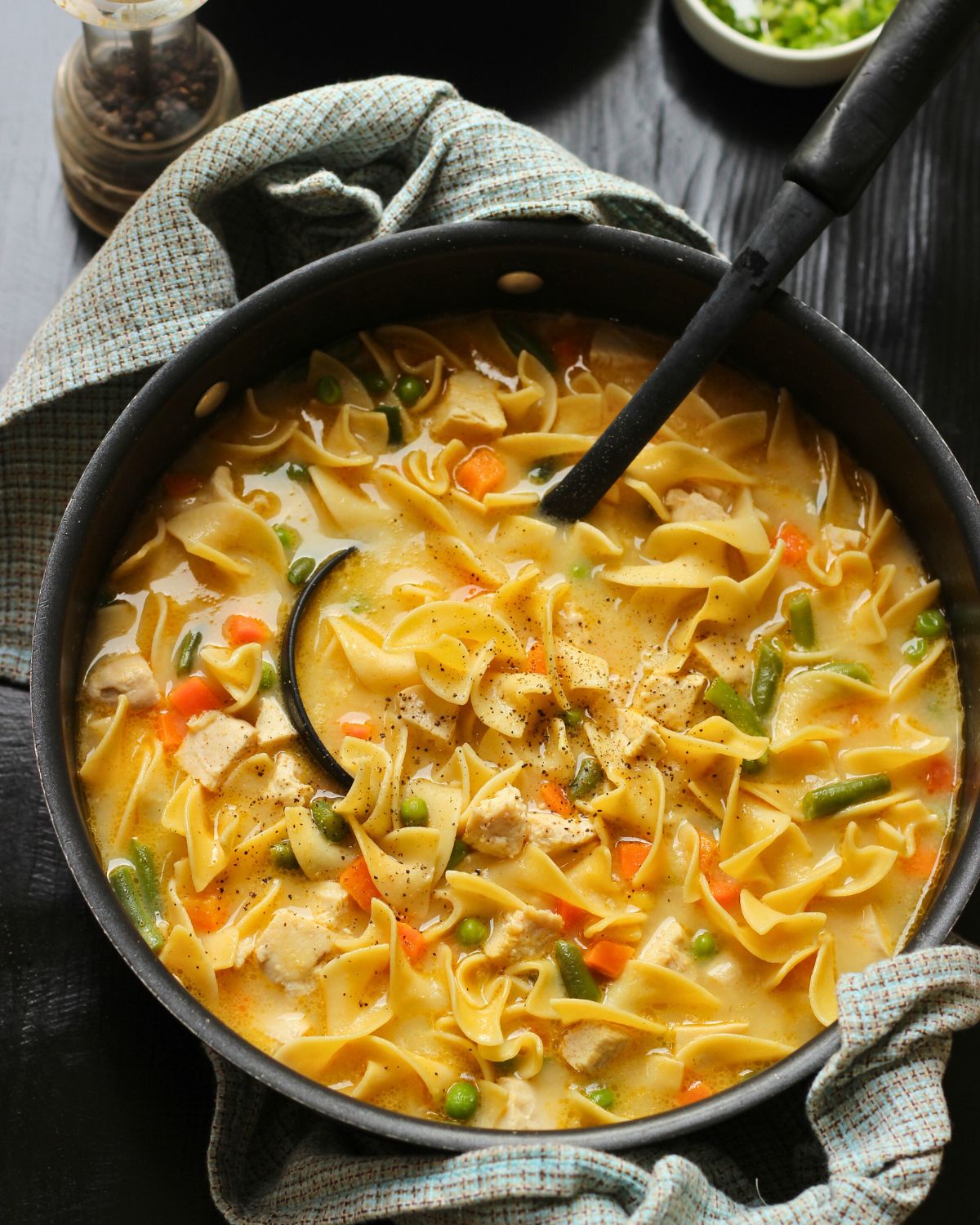 Creamy Hen Noodle Soup 5 pot of chicken noodle soup with black ladle.