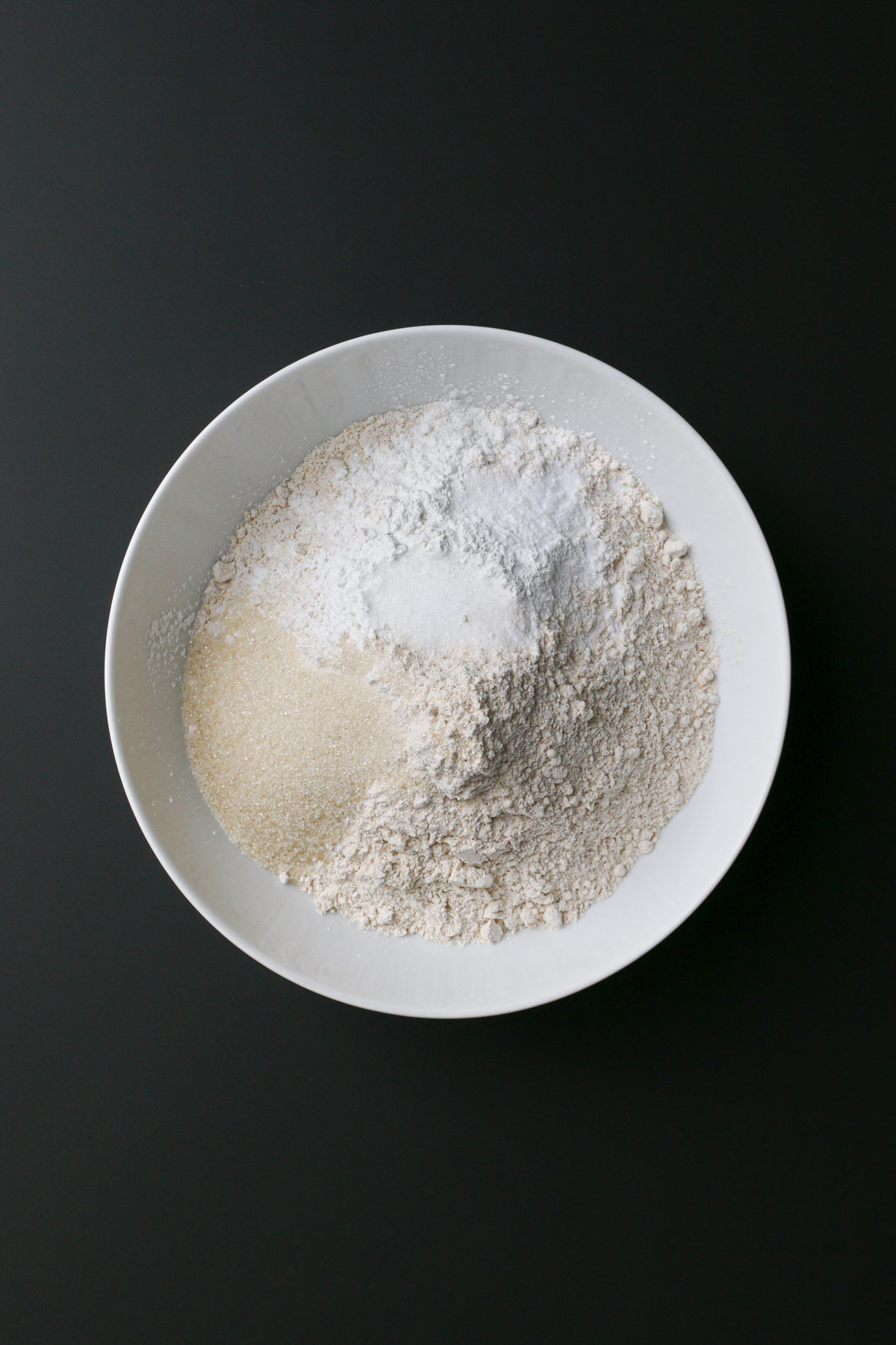 dry ingredients in a bowl on a black counter.