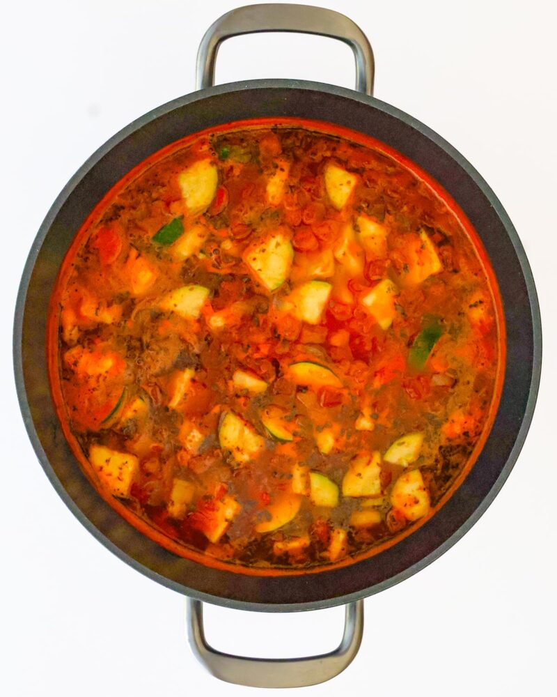 adding broth to simmer in the pot.