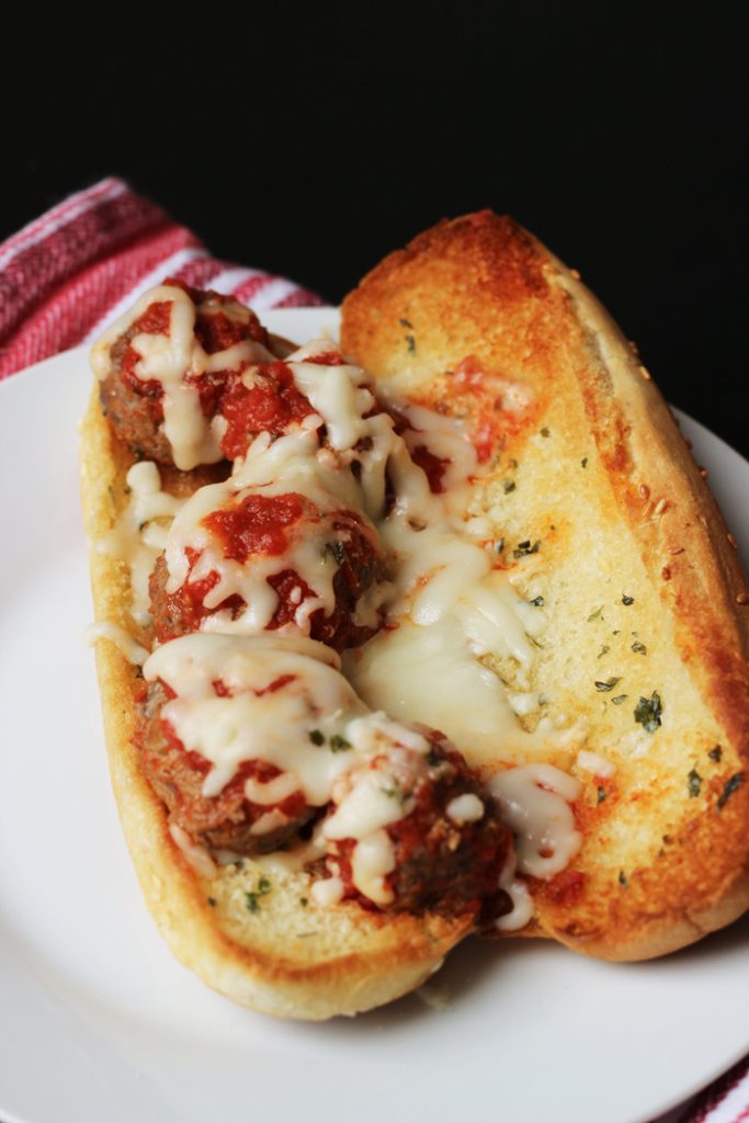meatball sub covered with marinara and cheese