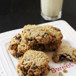 oatmeal cookies on a white plate with glass of milk
