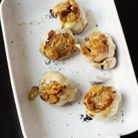 a platter of roasted garlic heads