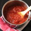 Homemade Pizza Sauce in a small pot with wooden spoon