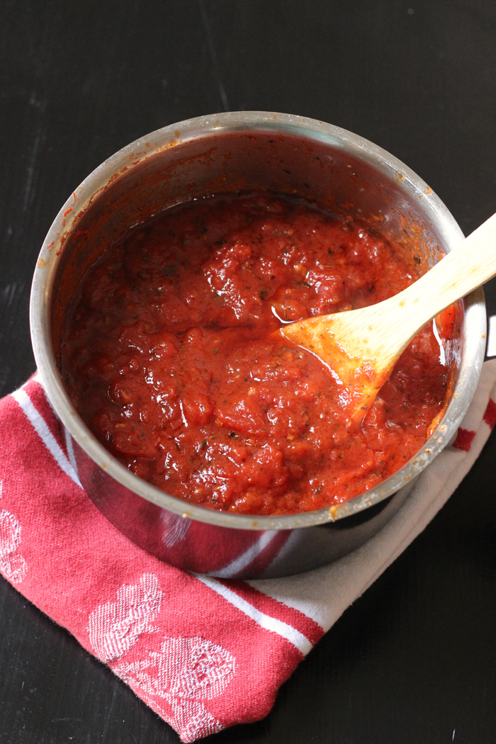 Homemade Pizza Sauce in a small pot with wooden spoon