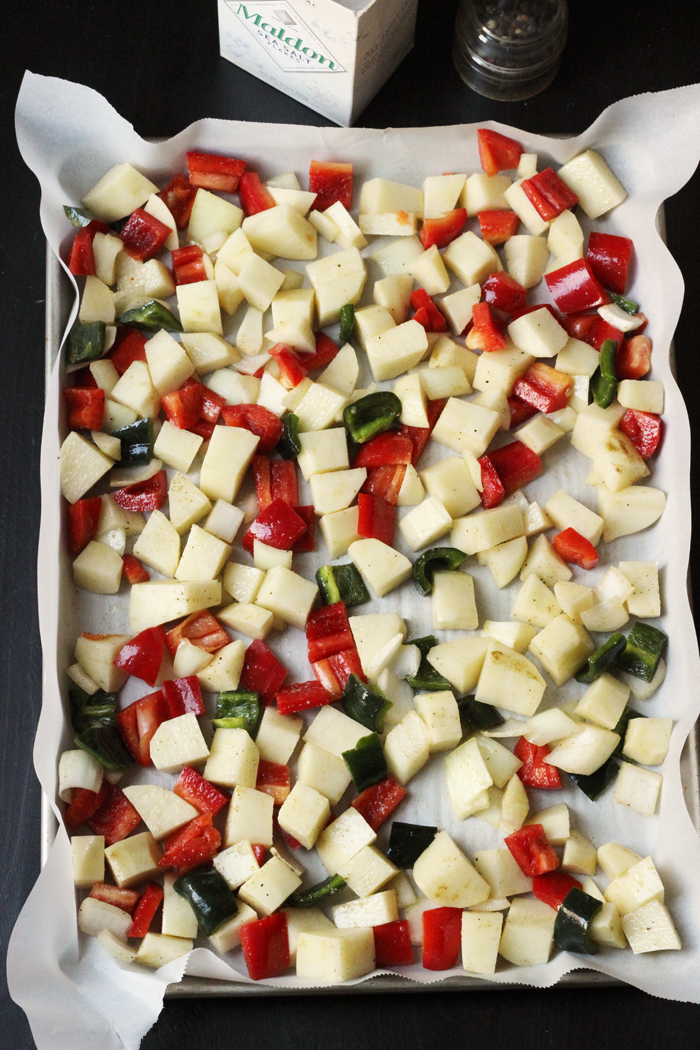 raw potato and pepper cubes on lined tray