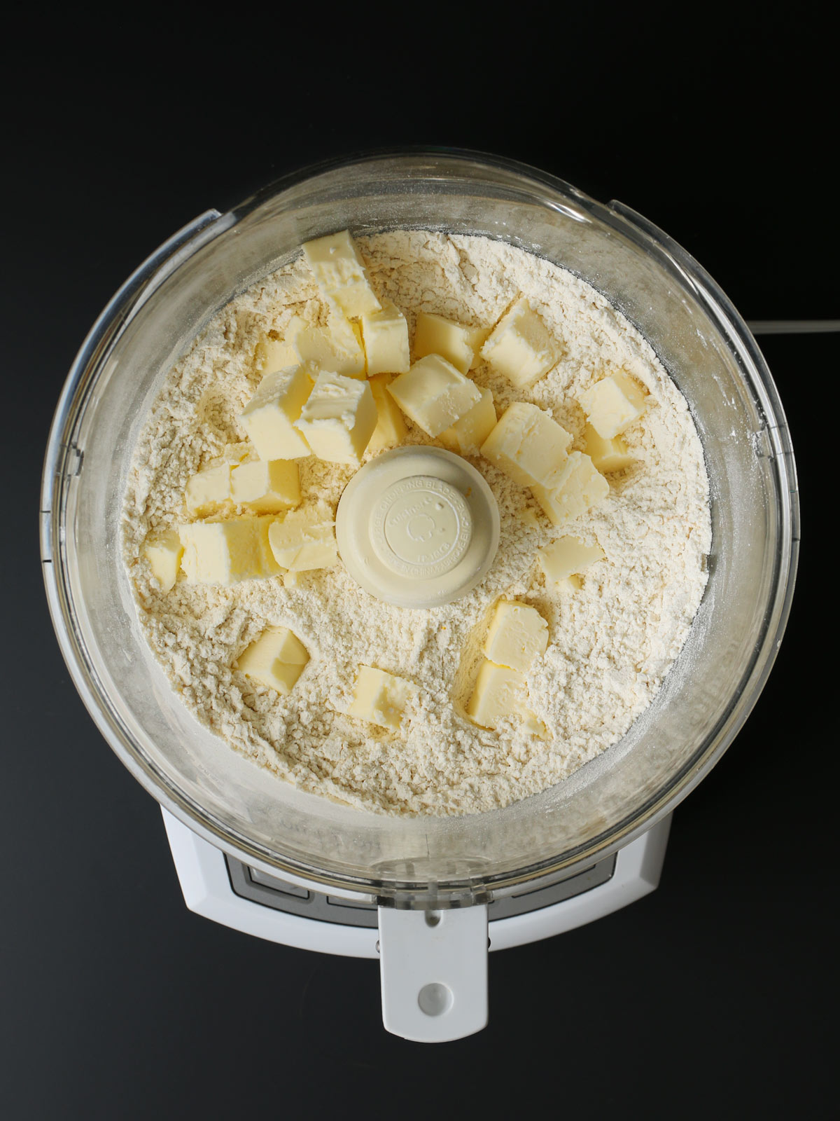 butter cubes added to food processor bowl.
