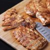 chicken breasts sliced on wooden cutting board