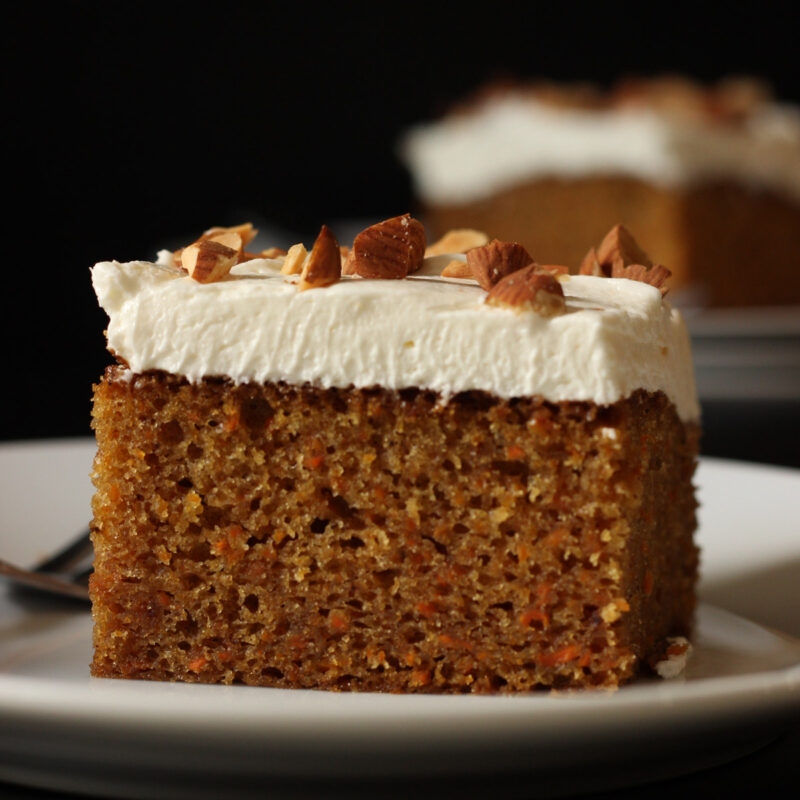 square of carrot cake topped with cream cheese frosting.