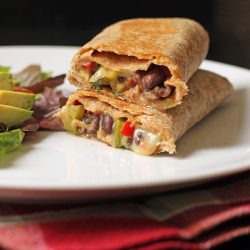 black bean and pepper wrap cut open and stacked on a plate