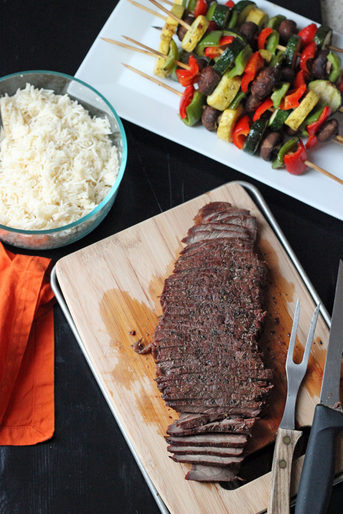 grilled steak on cutting board with rice and kabobs platters