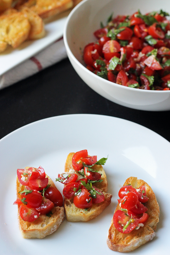 A plate of food on a table, with Toast and Tomato Salad