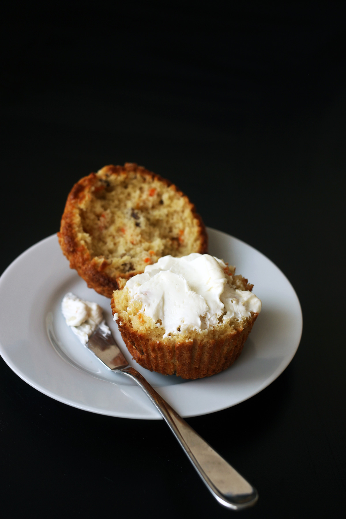 split carrot muffin with cream cheese spread on half