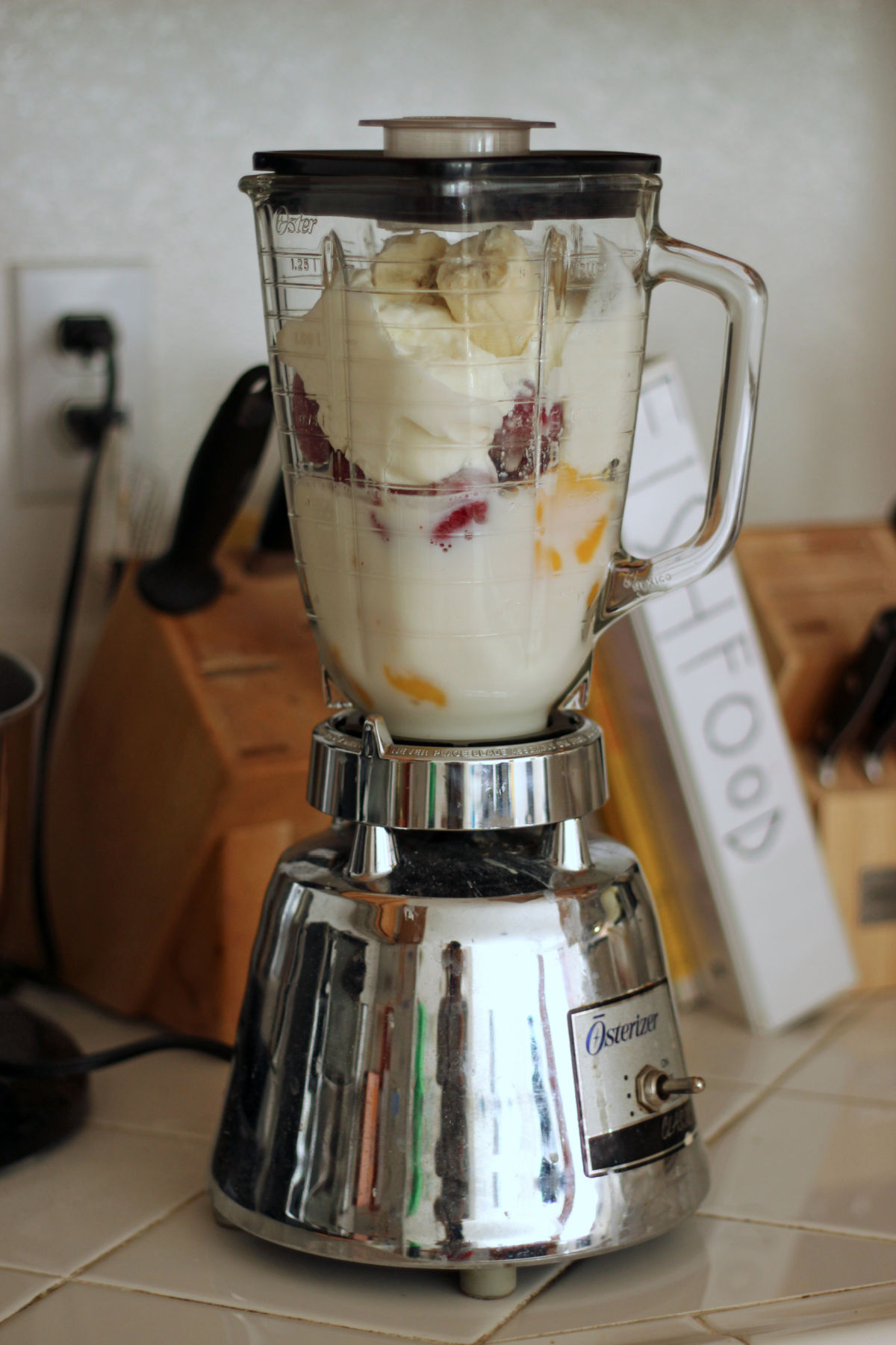 classic beehive blender filled with strawberries, mango, bananas, milk, and yogurt