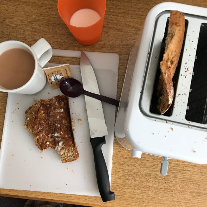 toaster next to prepped toast and tea