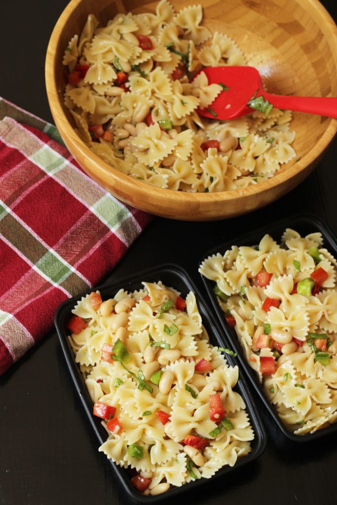 bowl of bowtie pasta salad with meal prep boxes