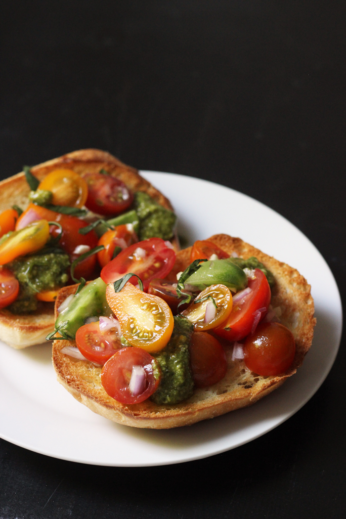 A plate of bruschetta toasts piled with tomatoes