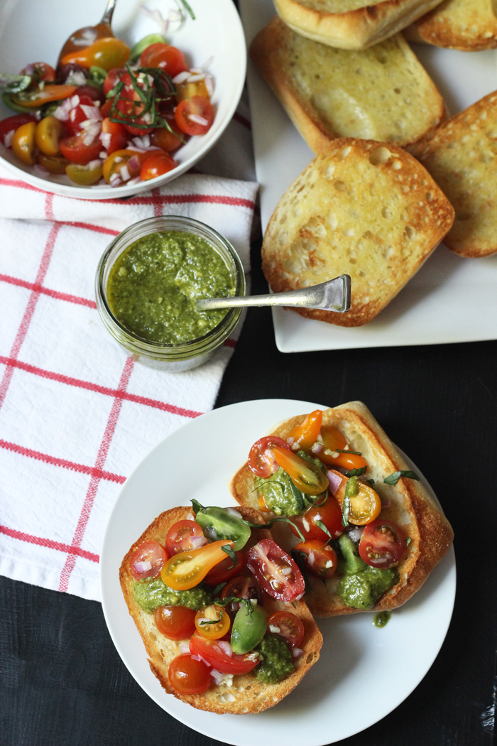 Pesto Bruschetta in a bowl, bread, jar of pesto