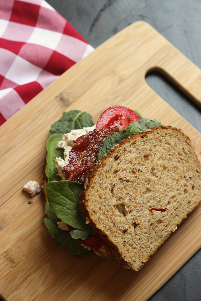 Chicken Salad Club Sandwich with bacon on a cutting board