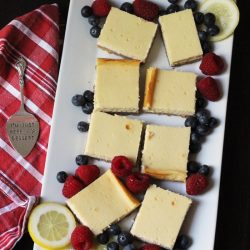 tray of cheesecake squares with fresh berries