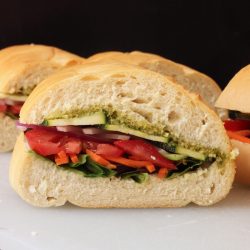 A close up of a Veggie Pesto sandwich on a cutting board