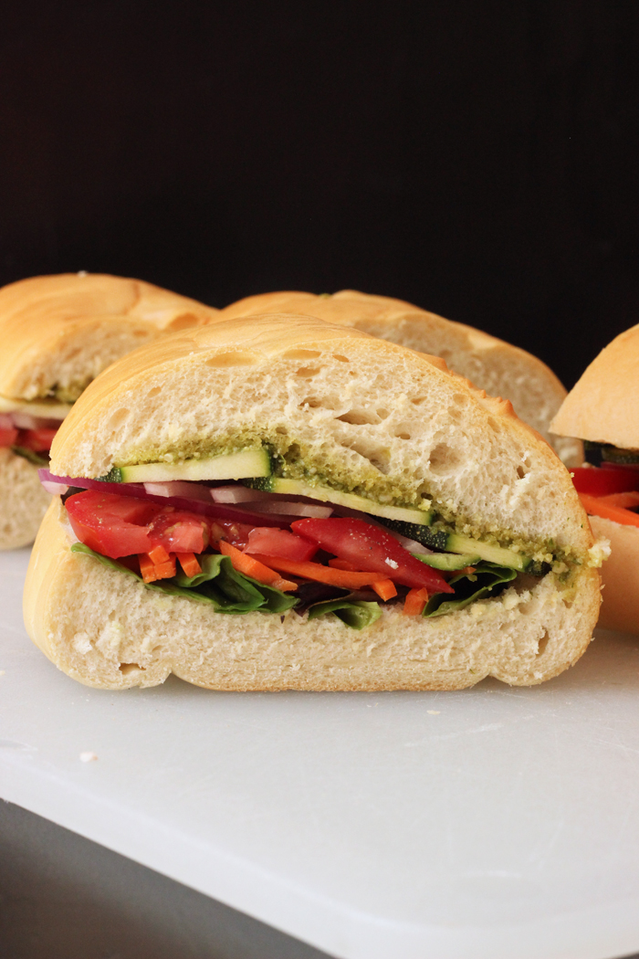 A close up of a Veggie Pesto sandwich on a cutting board