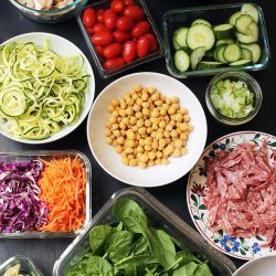 array of pasta salad toppings in different sized containers