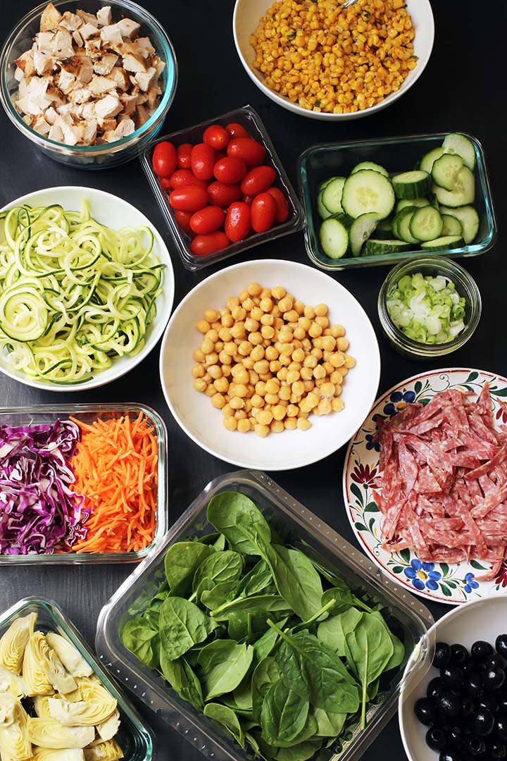 array of pasta salad toppings in different sized containers