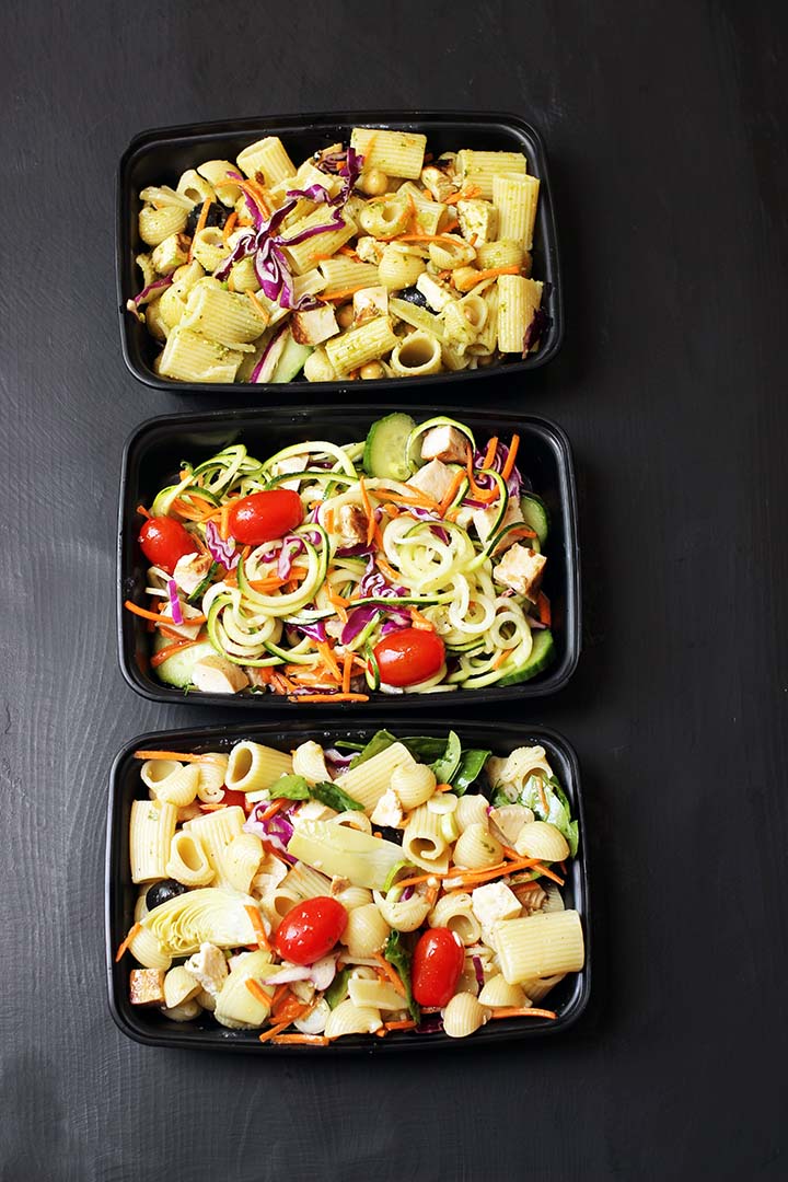 black meal prep containers with different pasta salads