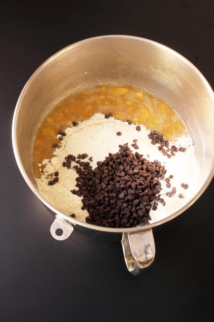 adding dry ingredients and chocolate chips to mixer