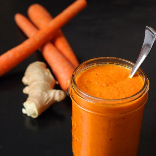 Carrots and ginger root with jar of dressing