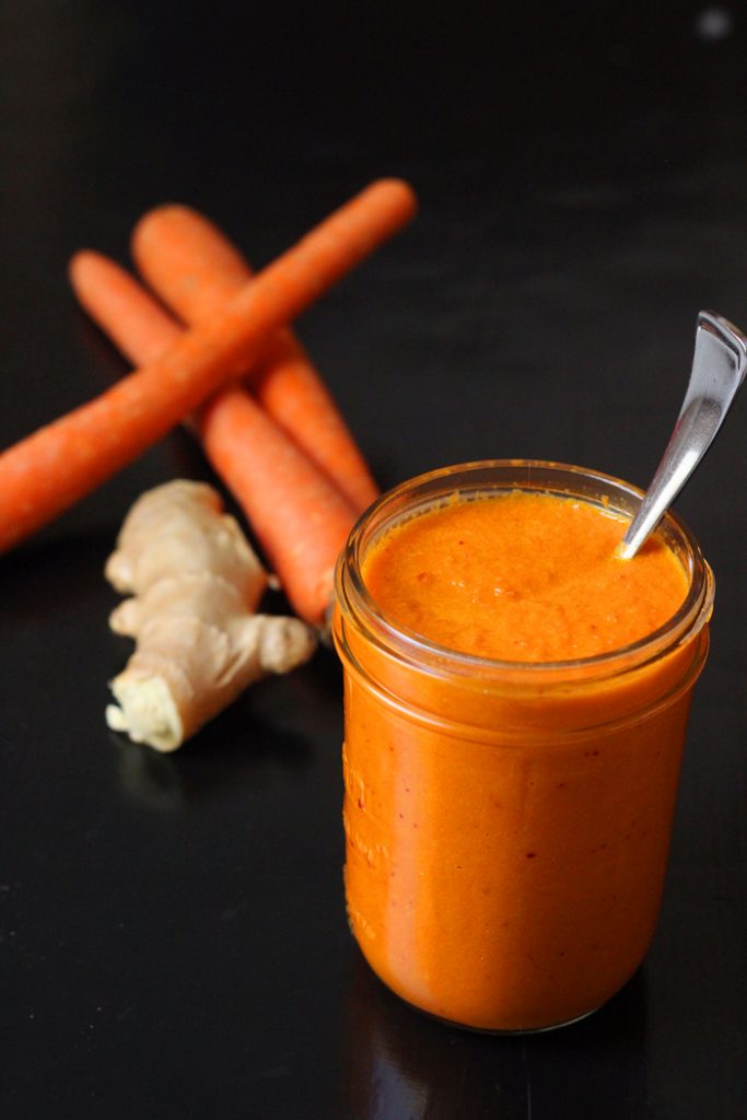 Carrots and ginger root with jar of dressing
