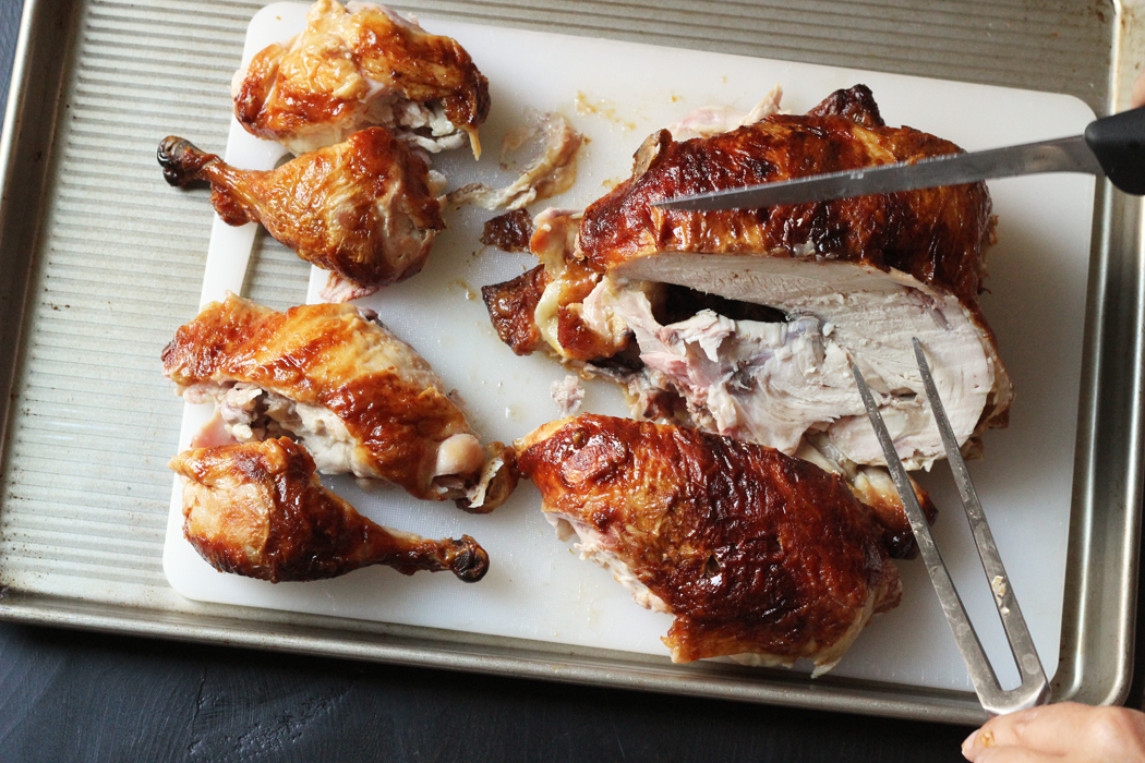 Messer schneidet Brustfleisch vom ganzen Huhn ab