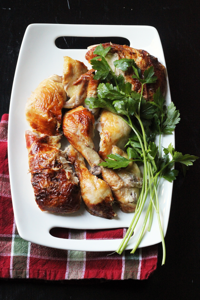 einem ganzen Huhn, das auf einer Platte mit Kräutern tranchiert wurde