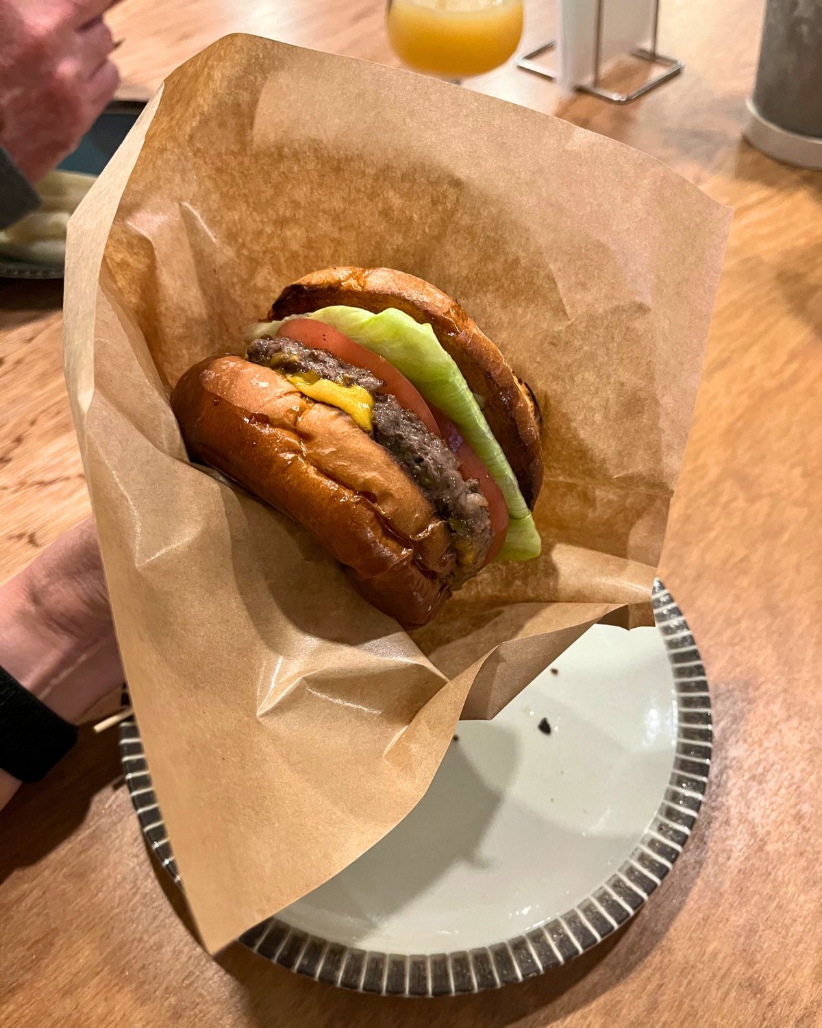holding a japanese burger in a paper envelope.