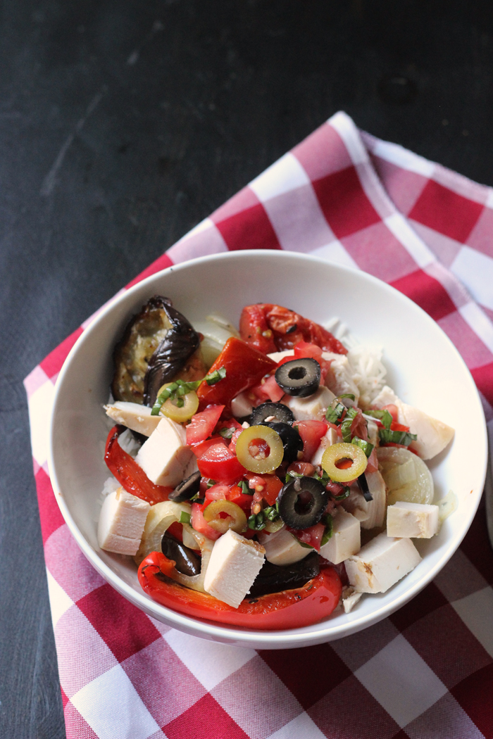 Mediterranean Chicken Bowl with rice on a red checkered napkin