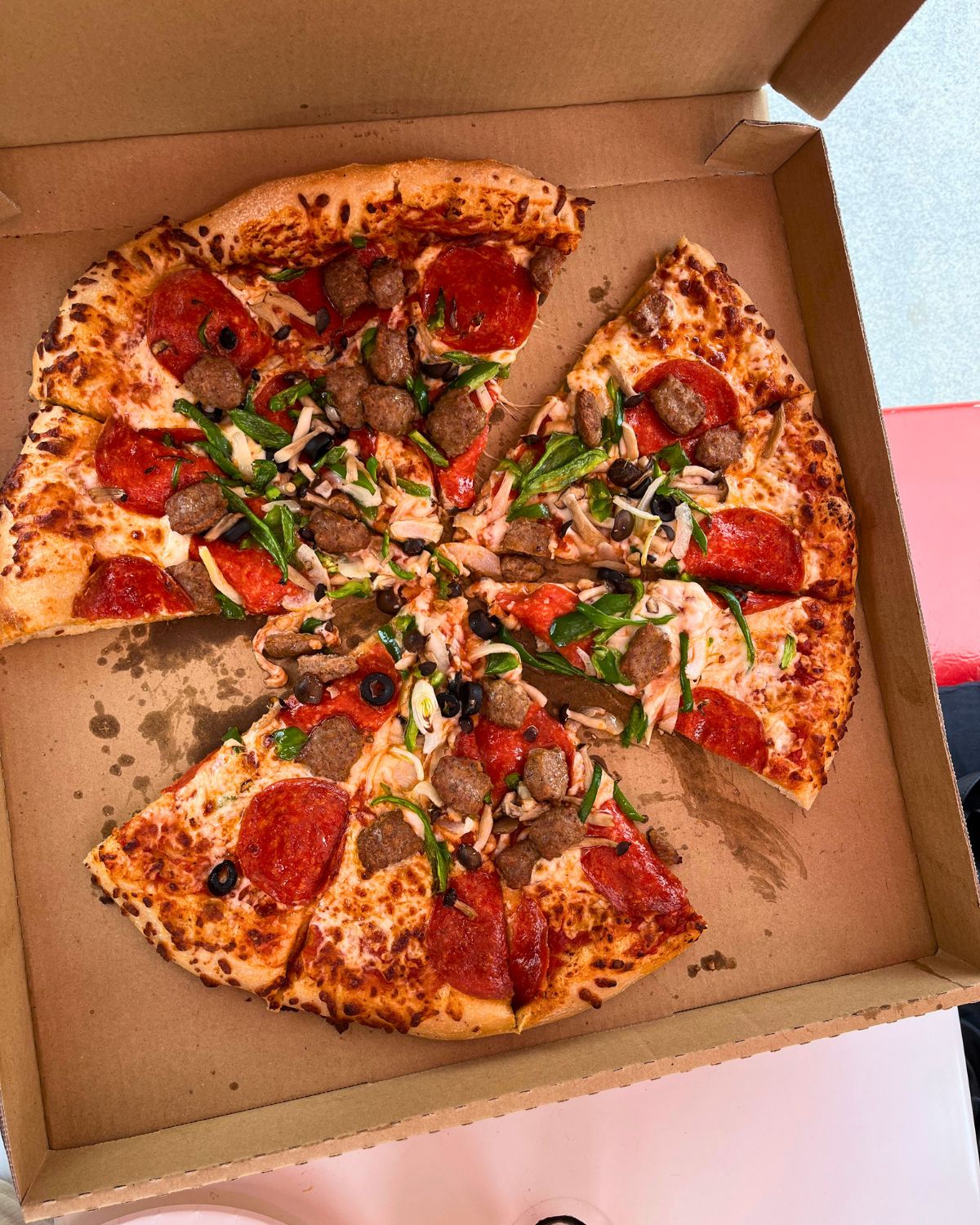costco pizza in opened box with slices removed.