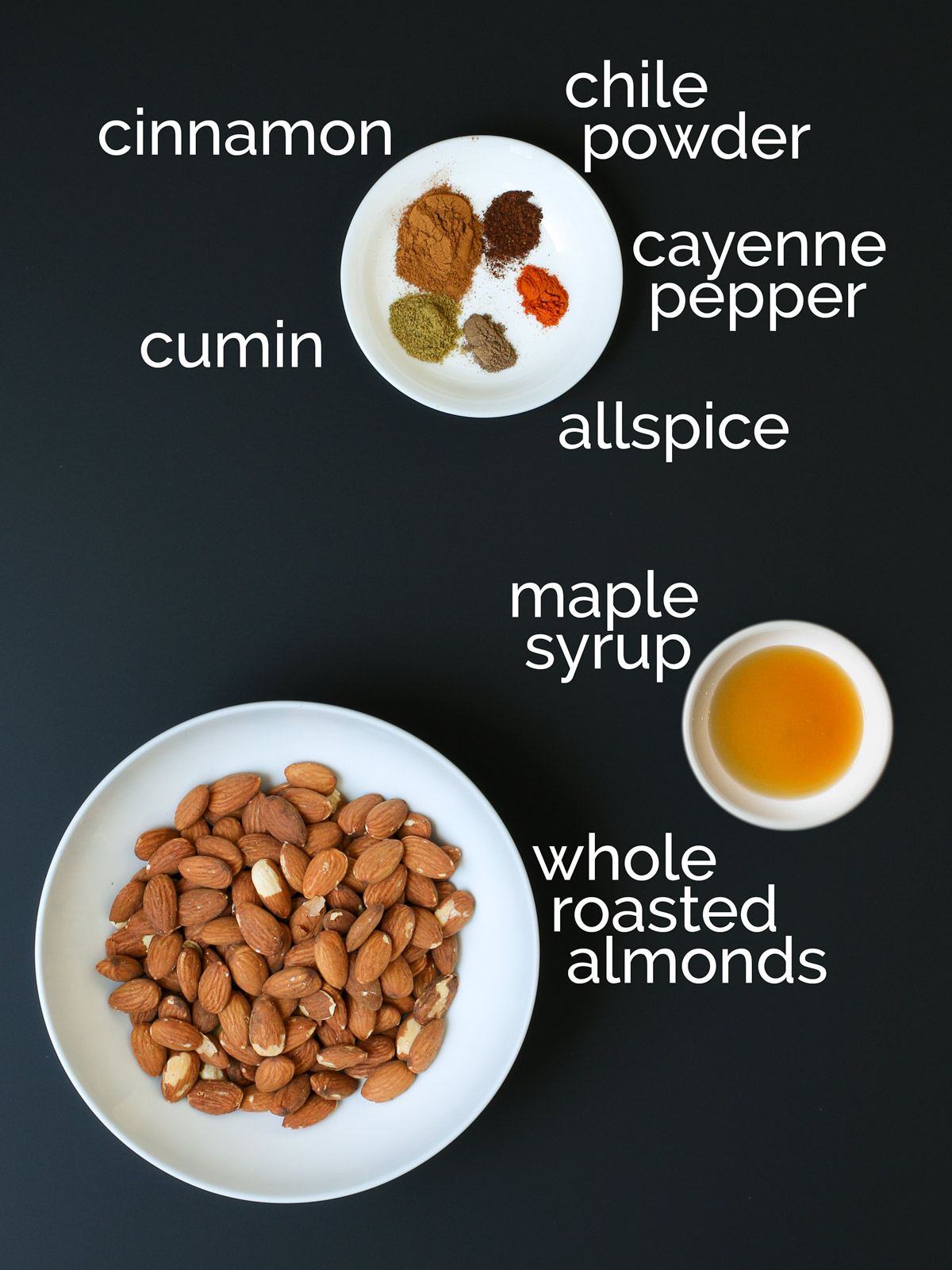 ingredients for spicy candied almonds laid out on black counter.