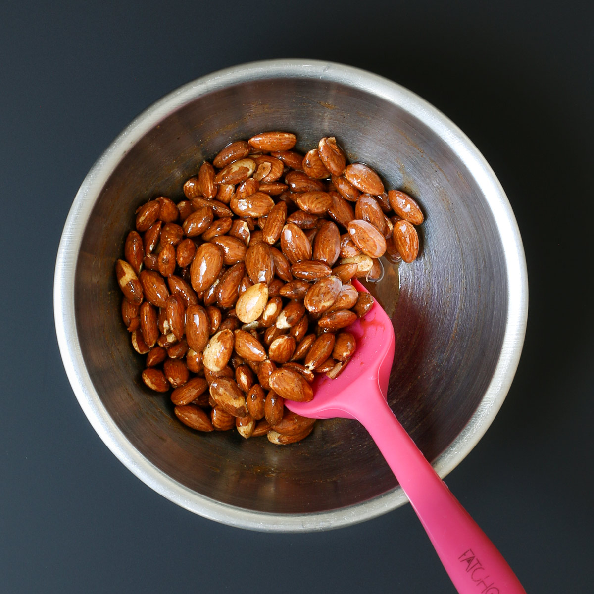 nuts stirred into syrup with red rubber spatula.