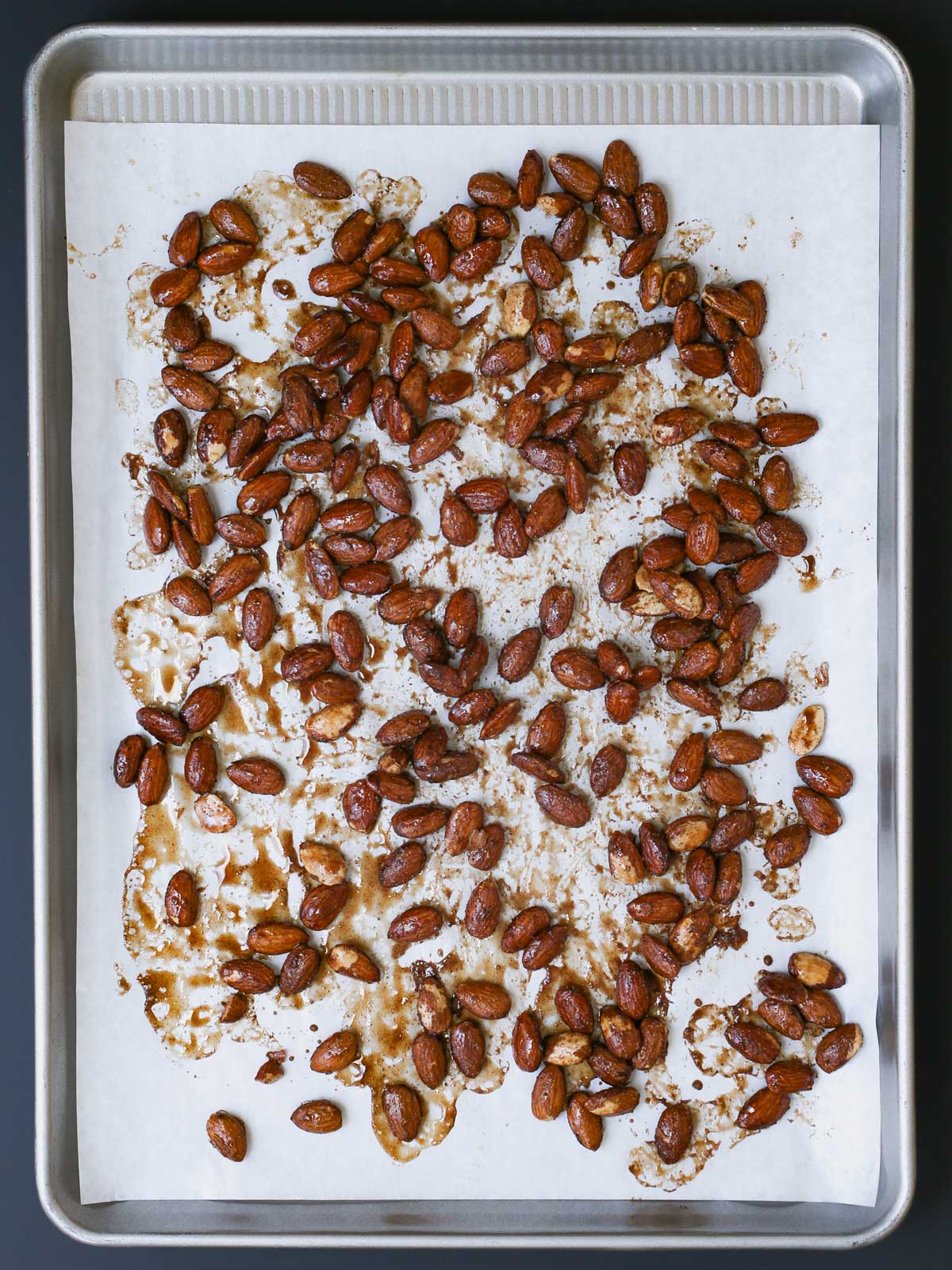 baked candied almonds on lined baking sheet.