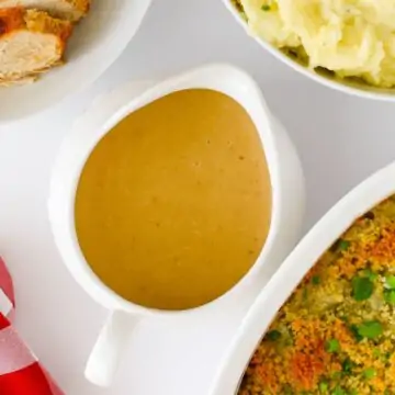 white gravy boat on dining table, surrounded by holiday dishes.