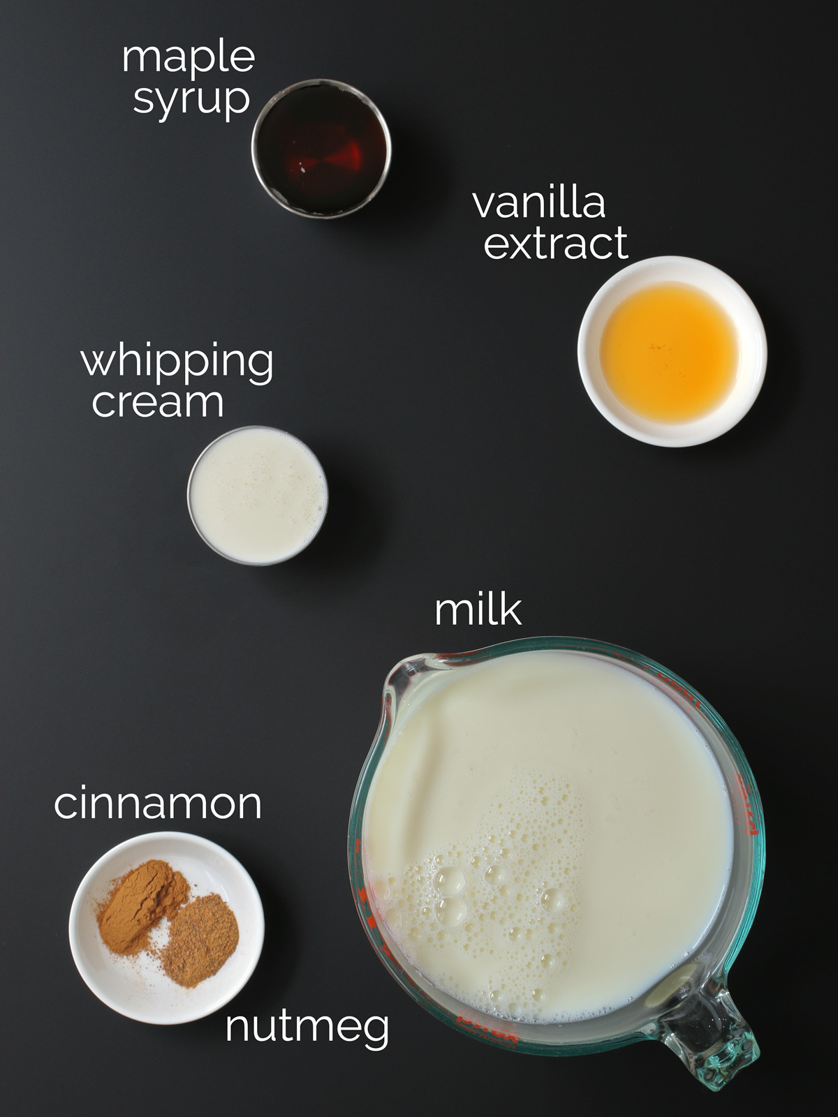 ingredients to make homemade milk nog on black counter.