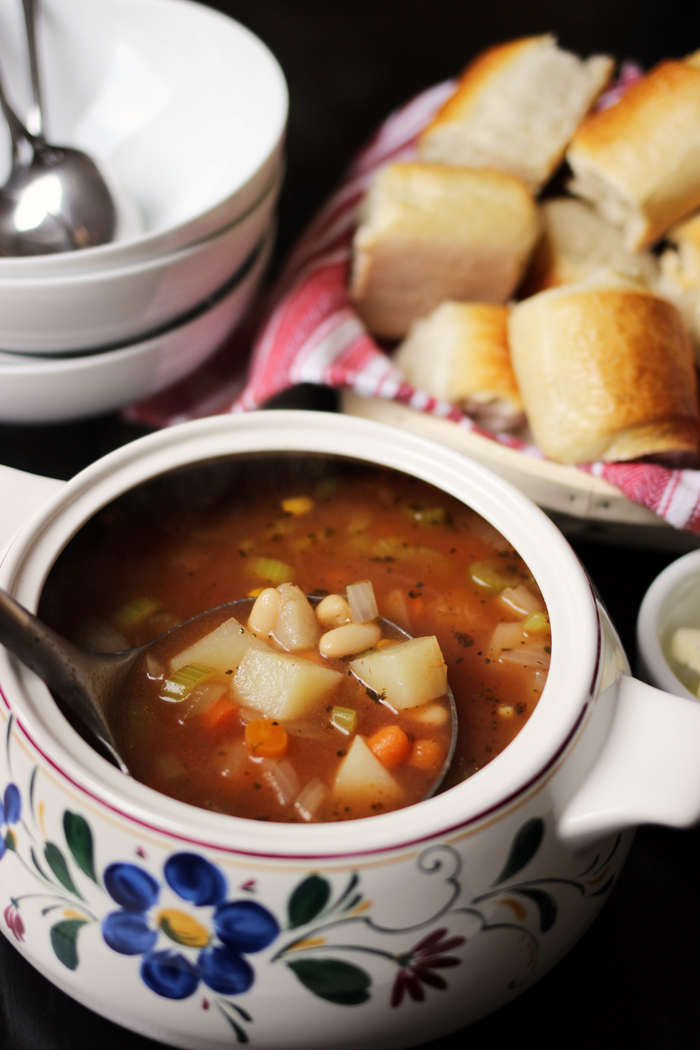 tureen of spicy vegetable soup with basket of rolls