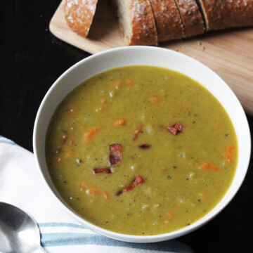 A bowl of pea soup, with bread