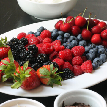 tray of berries with toppings on the side