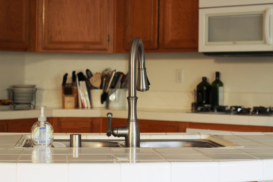 kitchen with stainless sink and white tile counters