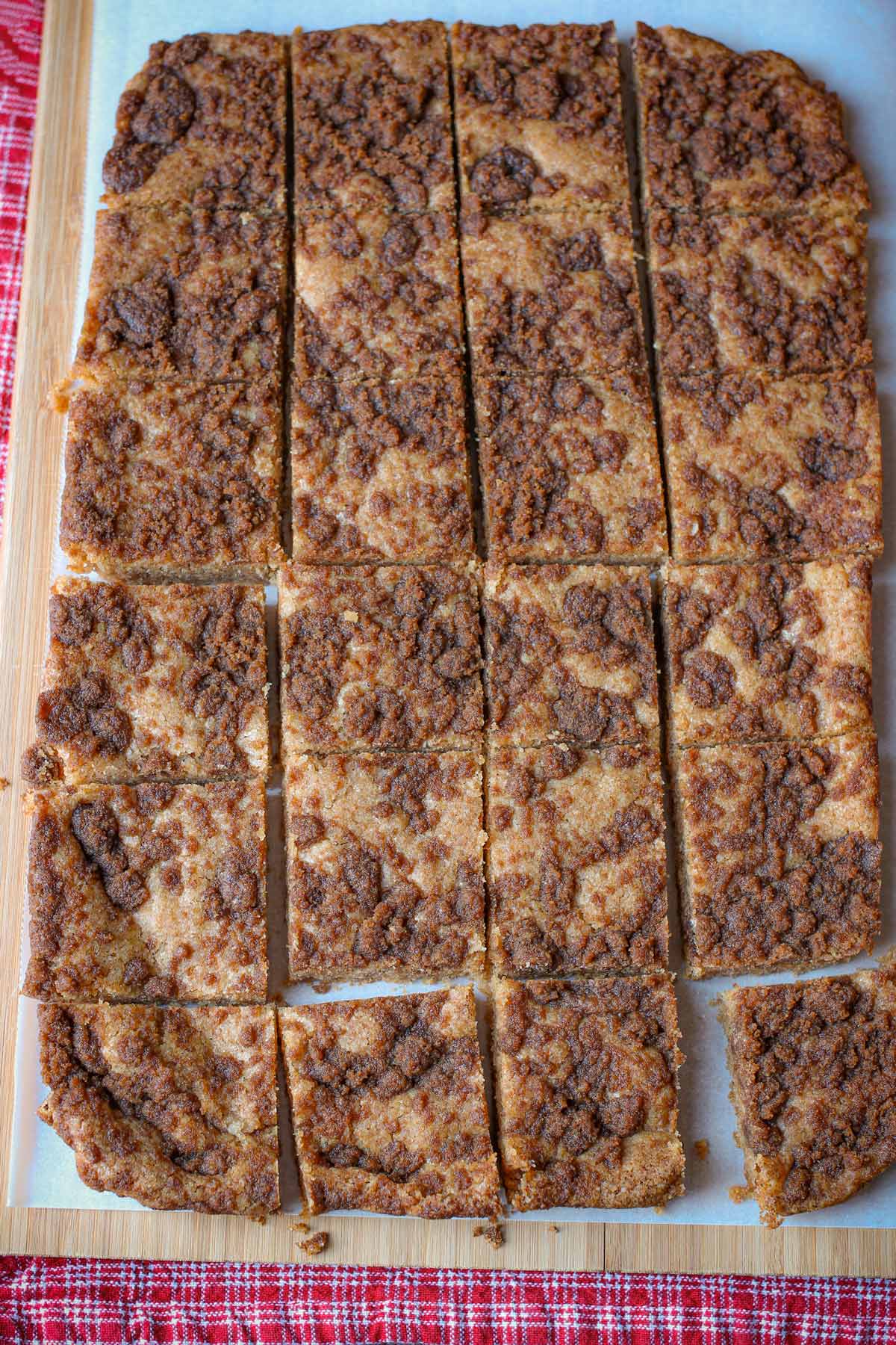 snickerdoodle bars on parchment cut into pieces.
