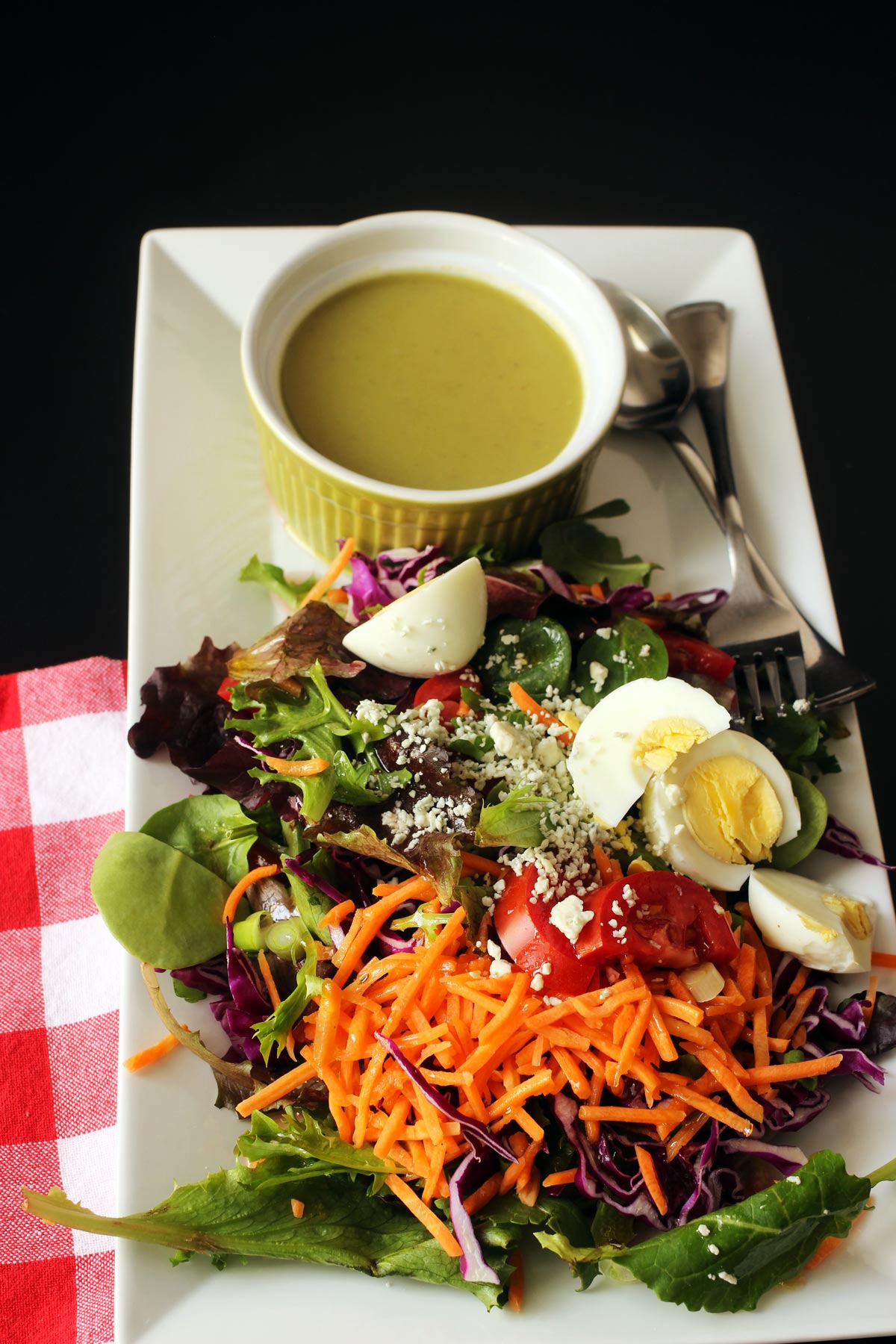 cup of soup on platter with salad