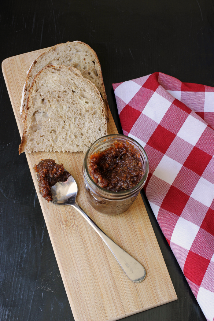 cutting board with english pickle, spoon and bread on it